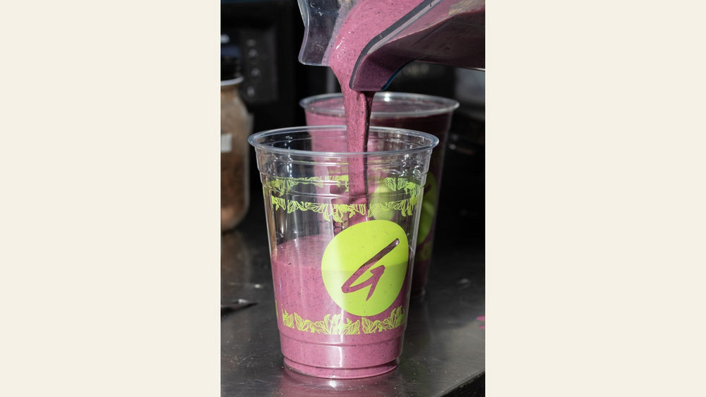 A berry smoothie being poured into a Griffy's Organics cup